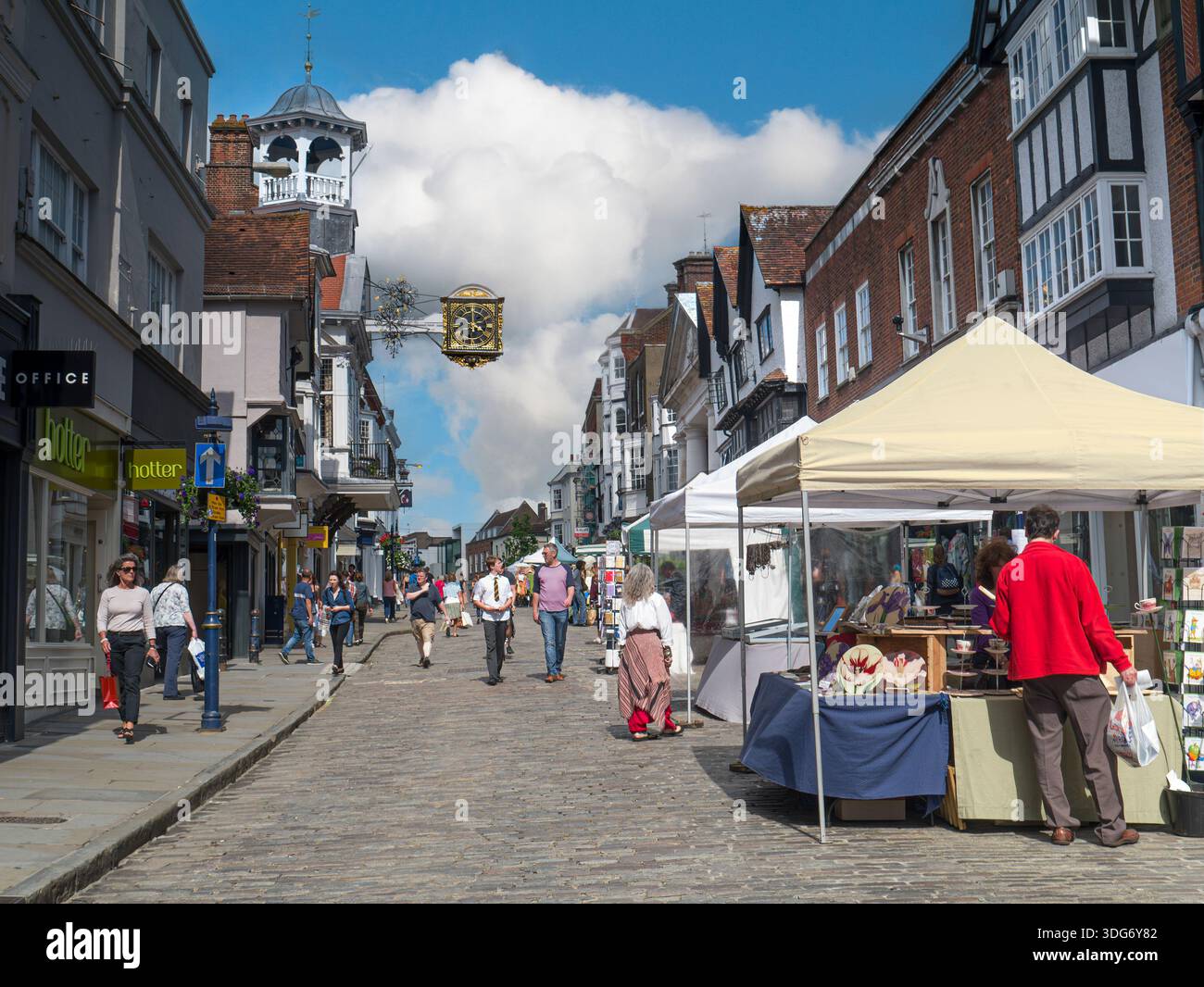 Giorno del mercato di Guildford storica High Street acciottolata, orologio e shopping simbolo, con bancarelle estive del mercato di artigianato locale Guildford Surrey Regno Unito Foto Stock