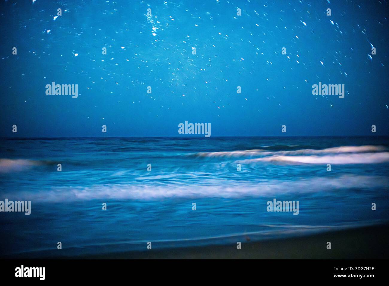 La lunga esposizione cattura il movimento delle onde sotto un cielo stellato a Isla Canela Beach ad Ayamonte, Huelva, Spagna. Ambiente tranquillo e tranquillo. Foto Stock