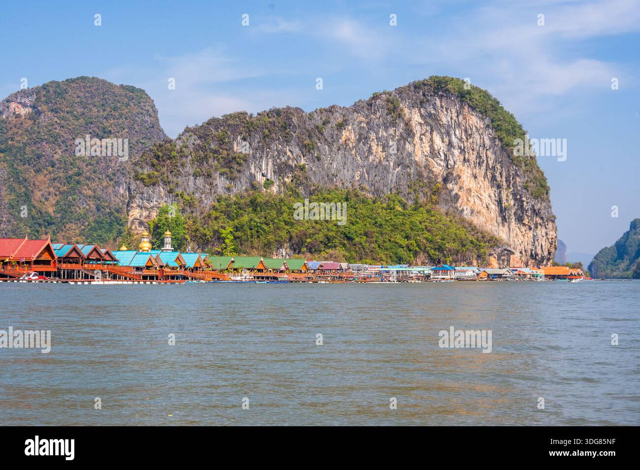 Koh Panyee. Febbraio 2025, Thailandia. Villaggio costiero di pescatori con fattorie galleggianti di pesci e case colorate sotto le torreggianti scogliere calcaree Foto Stock