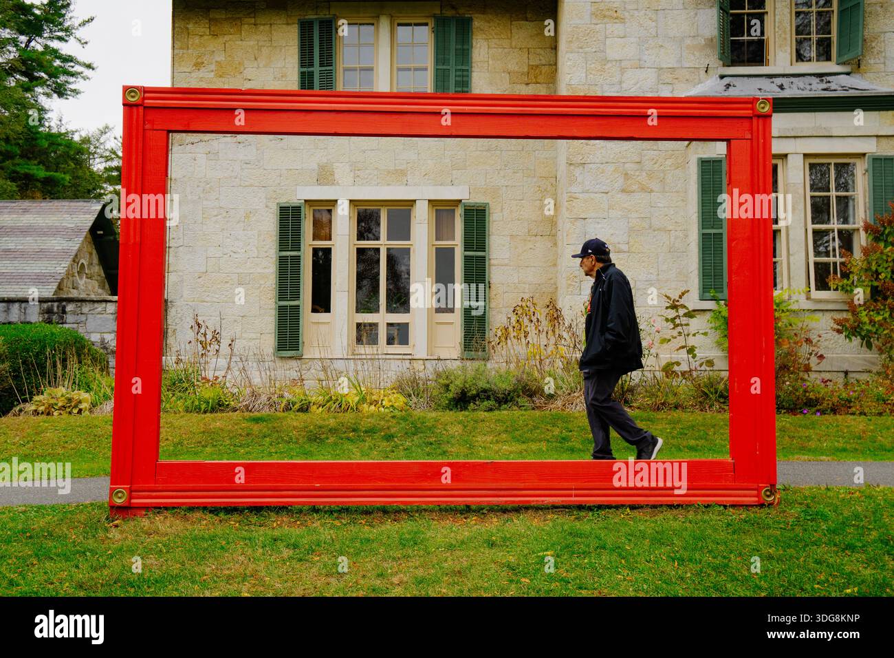 Uomo che cammina in una cornice rossa in campagna Foto Stock