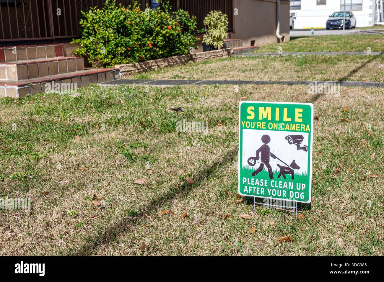 Little Havana Miami Florida, segnale di sicurezza, sorridi che sei sulla telecamera, segnale di videosorveglianza, pulisci dopo il messaggio del tuo cane, rifiuti di animali domestici remi Foto Stock