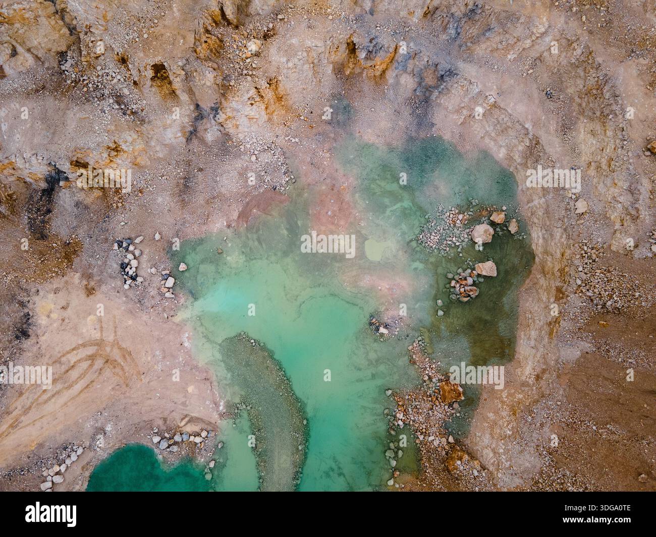 Vista aerea di un paesaggio ultraterreno, una piscina di acqua turchese annidata tra la terra aspra dai toni ocra, Foz do Arelho, Portogallo. Foto Stock