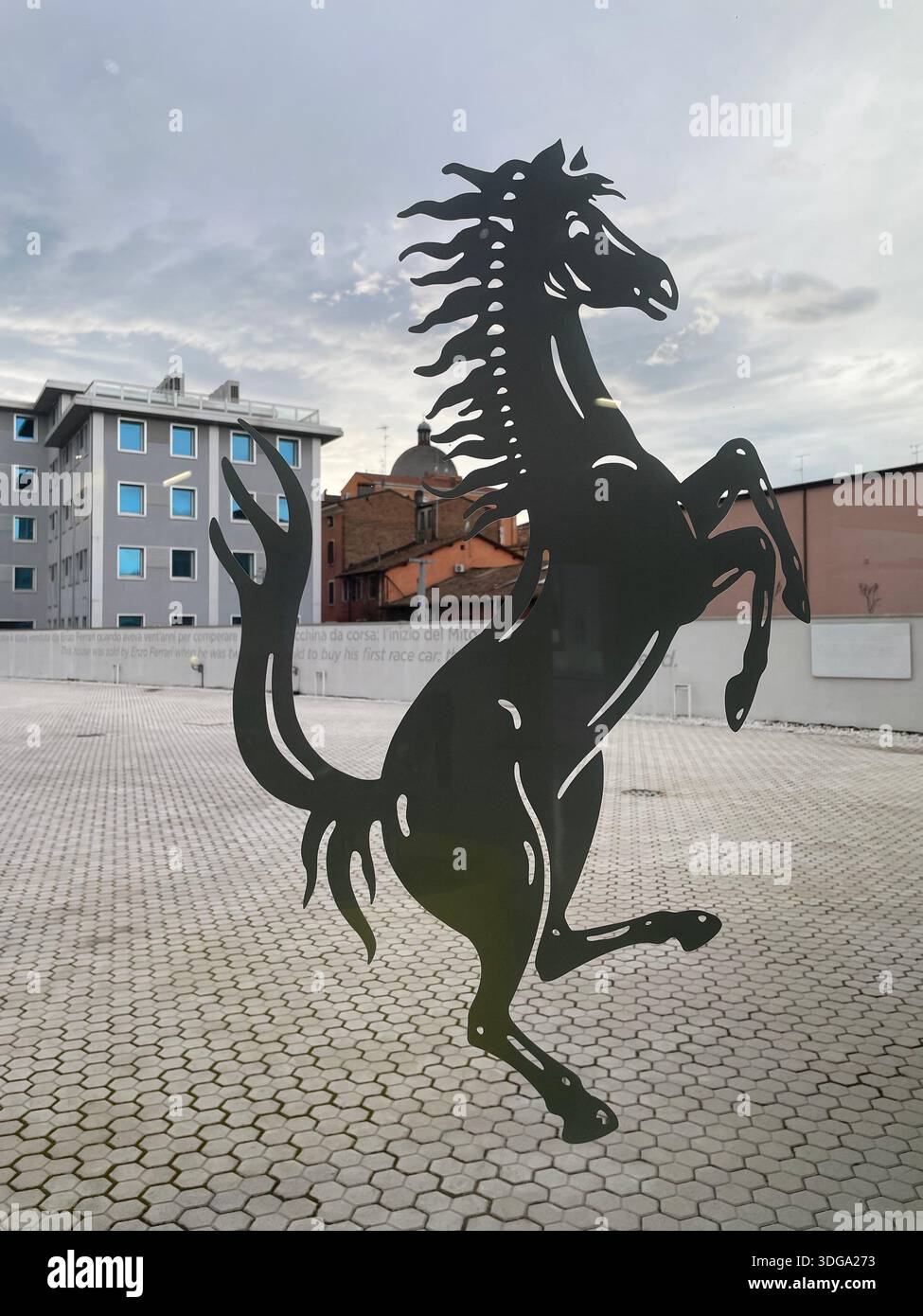 Cavallo rampante simbolo Ferrari come moderna scultura in metallo a Modena, Italia, che rappresenta il patrimonio automobilistico italiano e la cultura degli sport motoristici - Immagine stock catturata con smartphone