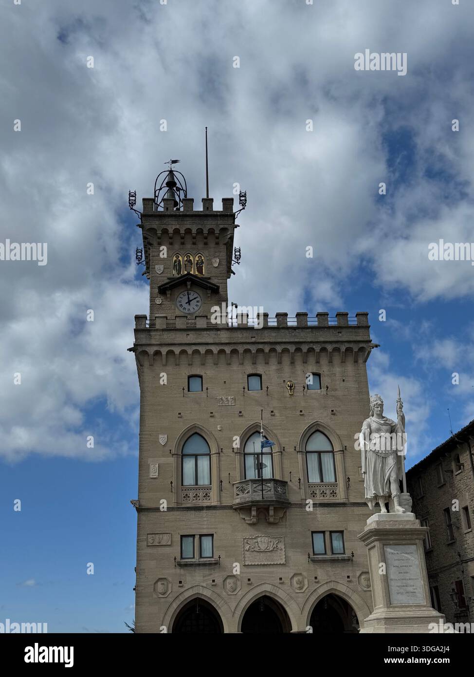 Palazzo pubblico a San Marino con la Statua della libertà, storico edificio governativo adagiato su un cielo blu con nuvole sparse. - Immagine stock catturata con smartphone