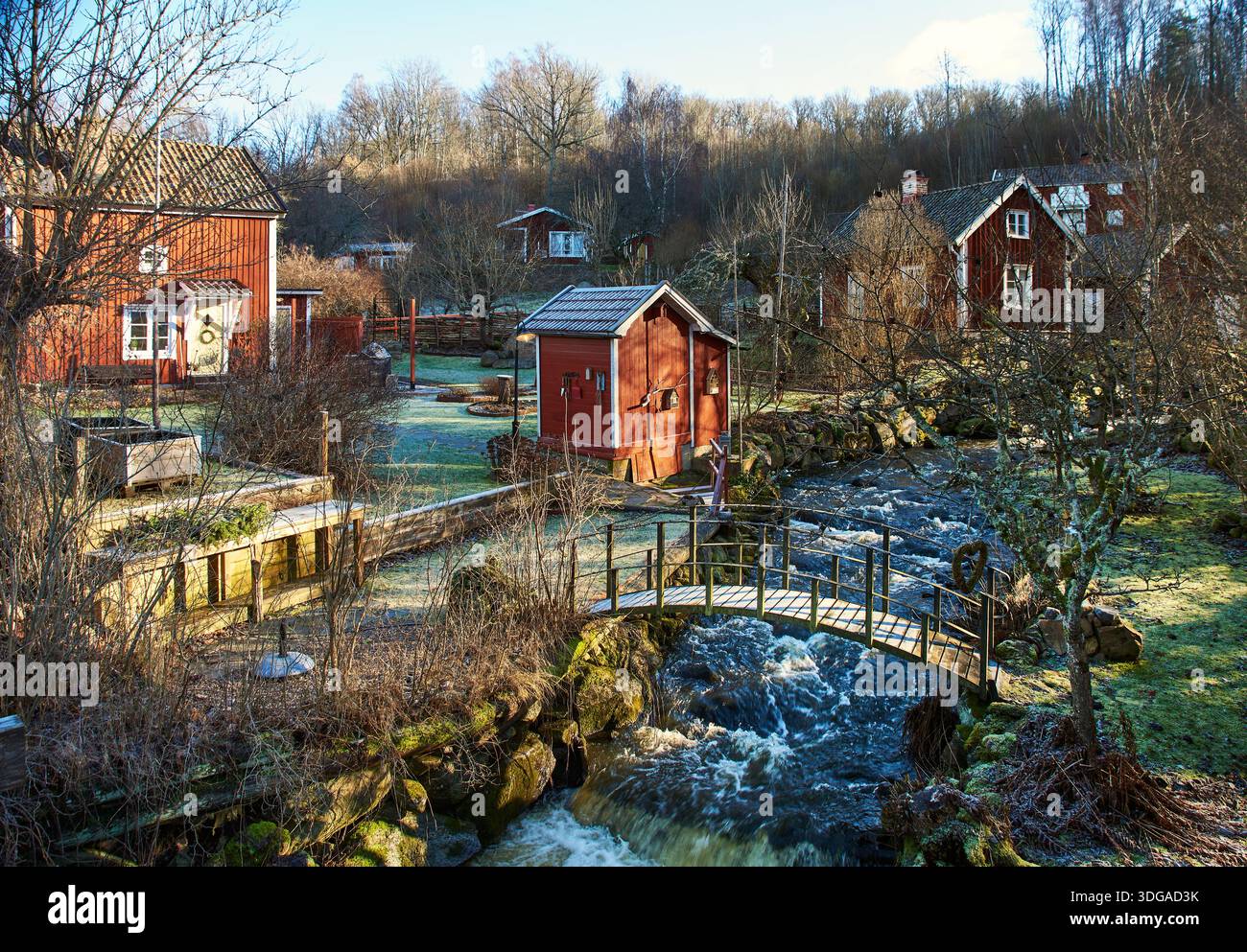 Villaggio svedese di Rottle, vicino a un ruscello vicino a Granna, Jonköping lan. Case di legno rosse e giardini ghiacciati annidati in una natura tranquilla Foto Stock