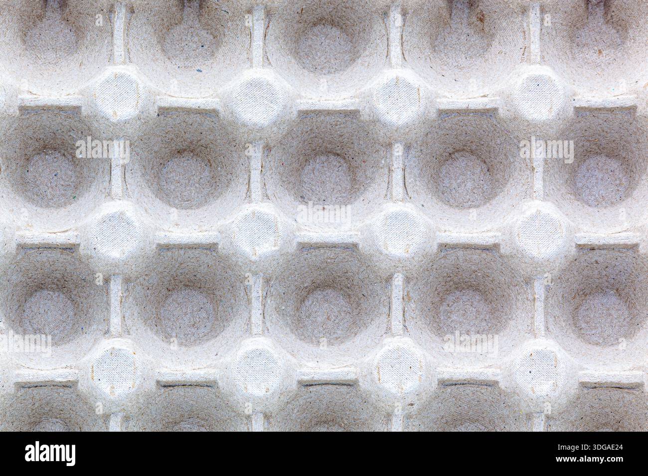 Ripetizione di celle vuote in un contenitore di uova di carta. Foto macro di tessuto di cartone riciclato. Concetto di imballaggio ecologico, riciclaggio Foto Stock