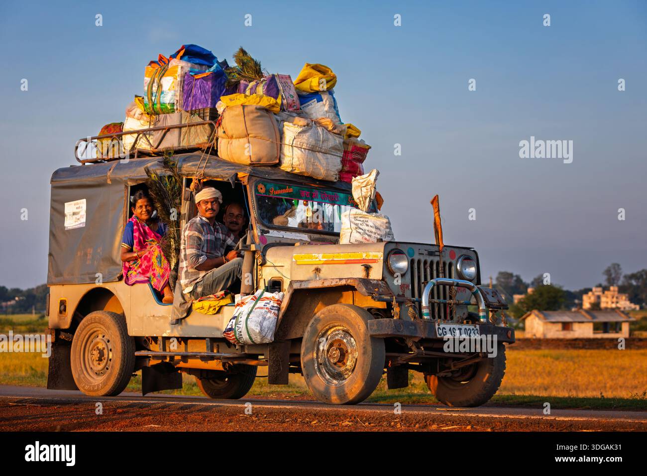 Persone che tornano da un mercato locale che trasportano merci, Chhattisgarh, India Foto Stock