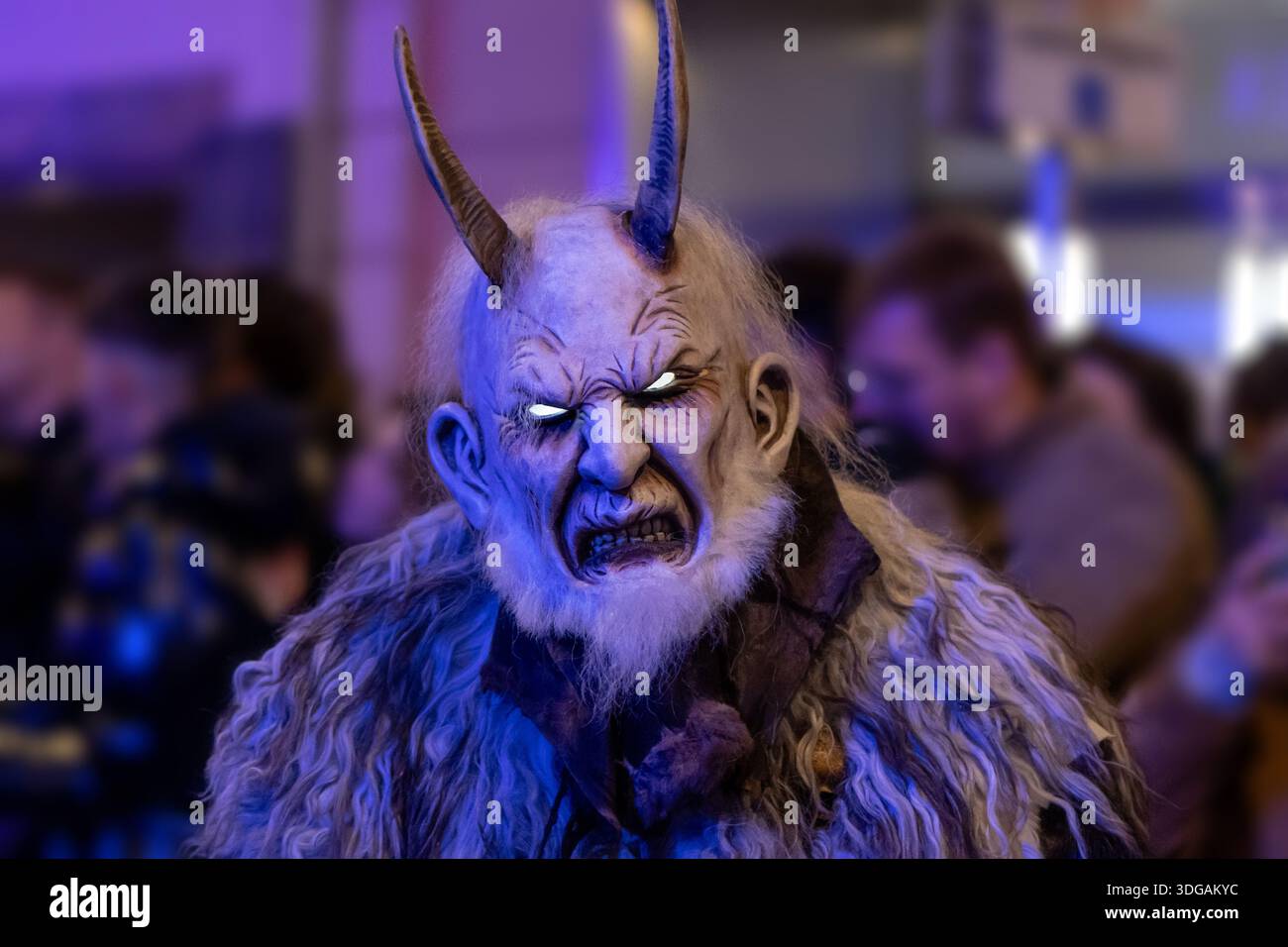 Krampus sotto la luce viola con occhi brillanti. Foto Stock