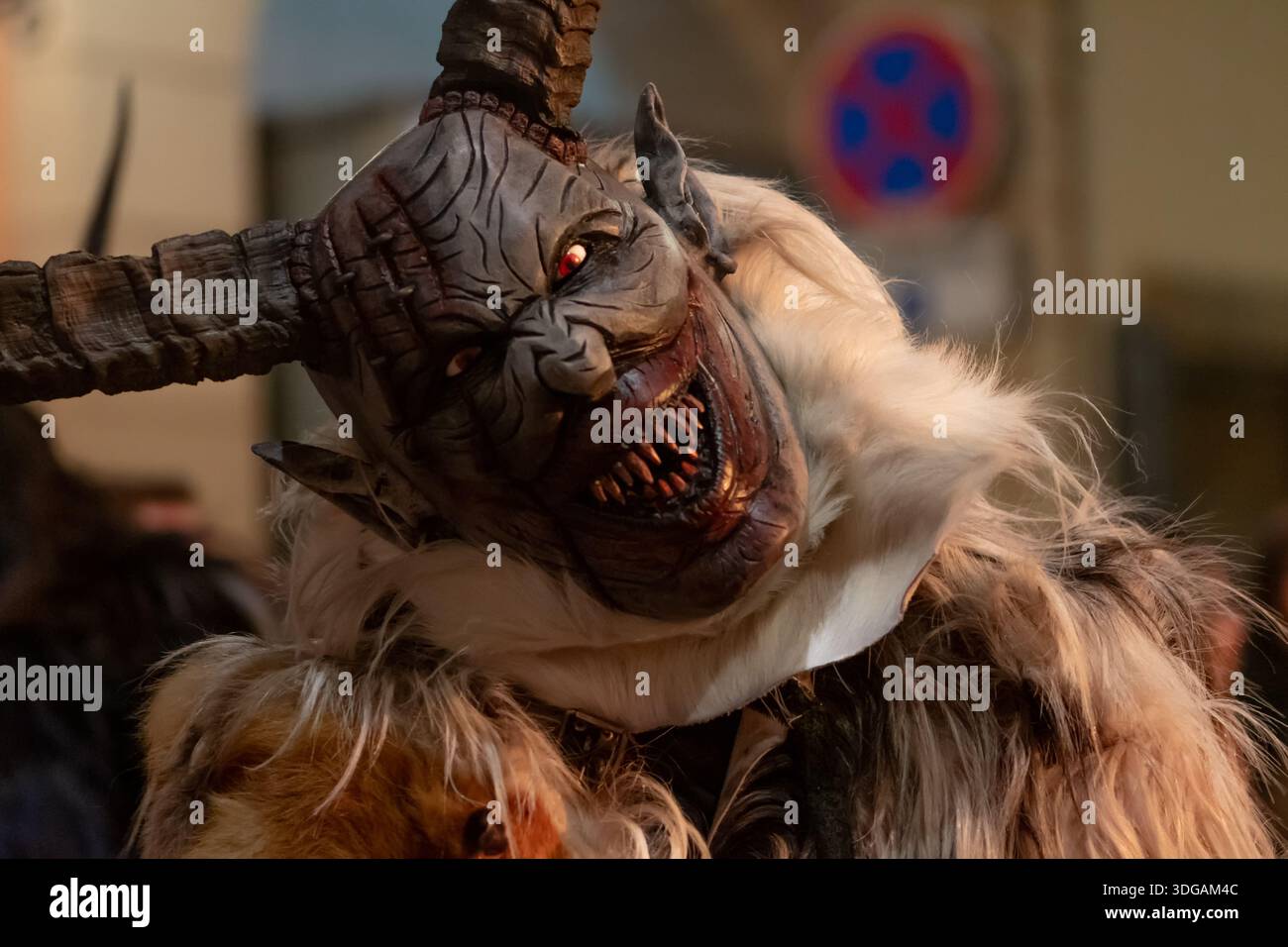 Krampus con testa inclinata, bocca agghiacciante e lungo corno catturato in primo piano Foto Stock