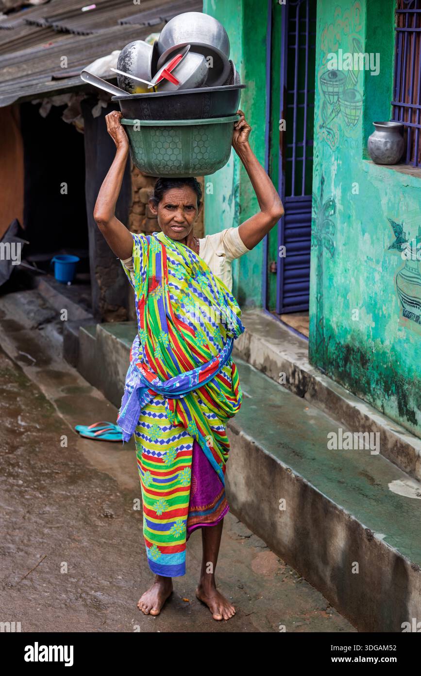 Ritratto di una donna anziana che porta pentole e padelle sulla testa, Orissa, India Foto Stock