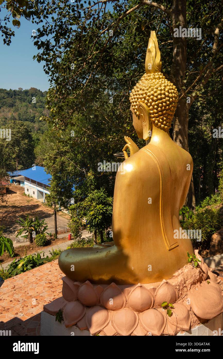 Thailandia, Ko Kood, costa meridionale, Ao Phrao, Wat Ao Phrao, tempio buddista tradizionale, statua dorata di Buddha sopra l'edificio scolastico del villaggio Foto Stock