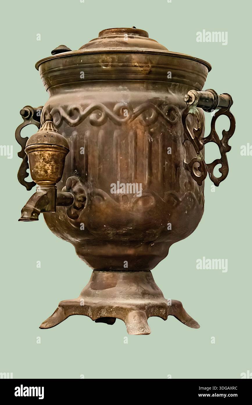 Un'antica caldaia d'acqua in ottone, nota come samovar, con una finitura opaca e dettagli ornati su sfondo verde isolato con percorso di ritaglio. Foto Stock
