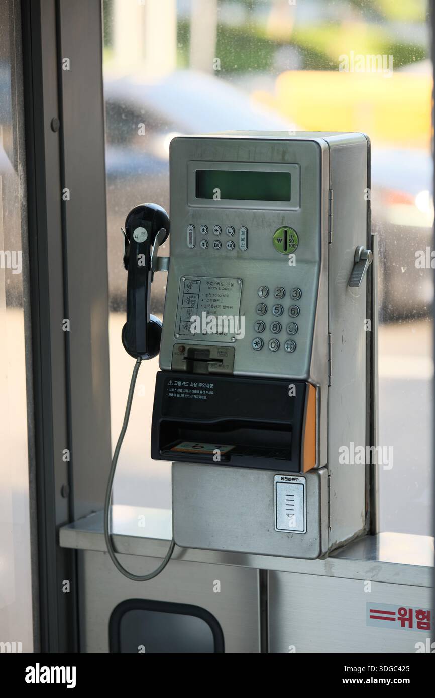 Seoul, Corea del Sud: Telefono pubblico a pagamento installato in interni con tastiera e ricevitore. Tecnologia di comunicazione telefonica tradizionale Foto Stock
