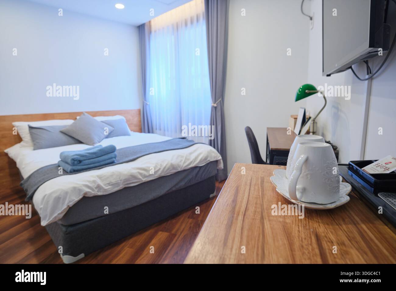 Seoul, Corea del Sud: Interni moderni con letto doppio, spazio di lavoro e illuminazione soffusa, che rappresentano la sistemazione in città Foto Stock