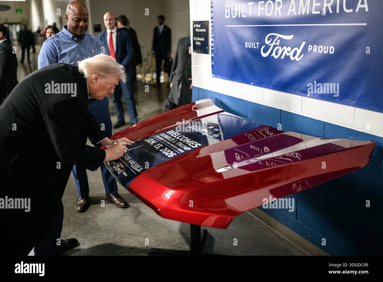 Il presidente Donald J. Trump firma un panel commemorativo durante una visita in uno stabilimento di produzione Ford a Detroit, Michigan, il 13 gennaio 2026. Per gentile concessione della Casa Bianca. Foto Stock