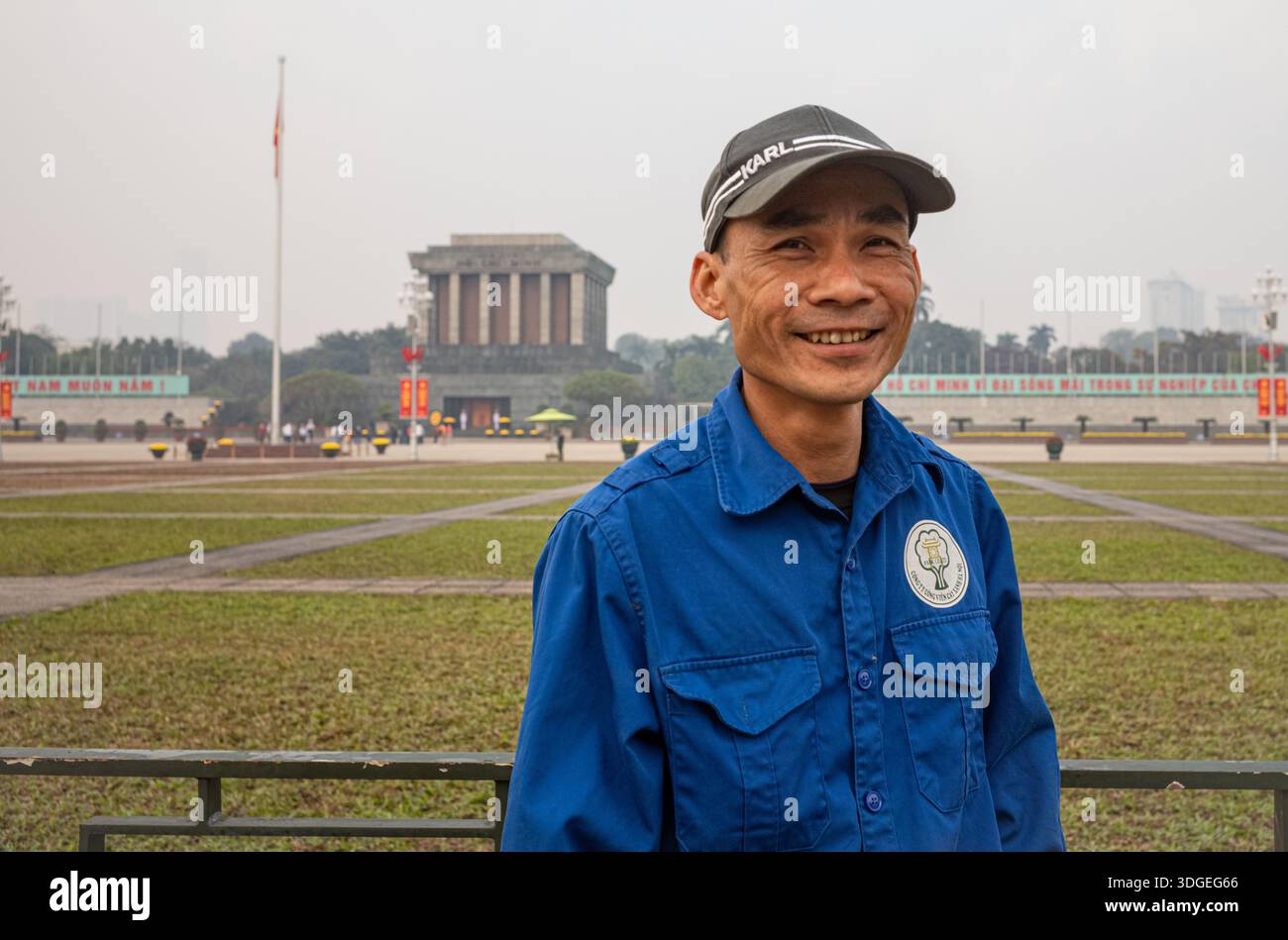Un giardiniere impiegato dallo stato in Piazza Ba Dinh fuori dal Mausoleo di ho chi Minh ad Hanoi in una giornata nebbiosa e gravemente inquinata. La città è in fase di allestimento Foto Stock