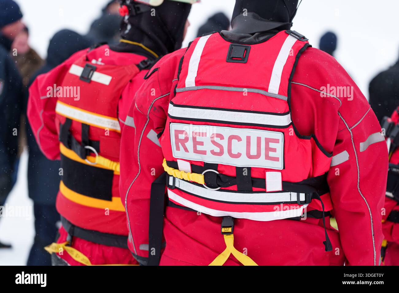 Vista posteriore del soccorritore in gilet di sicurezza rosso con imbracatura durante il funzionamento di emergenza. Foto di alta qualità Foto Stock