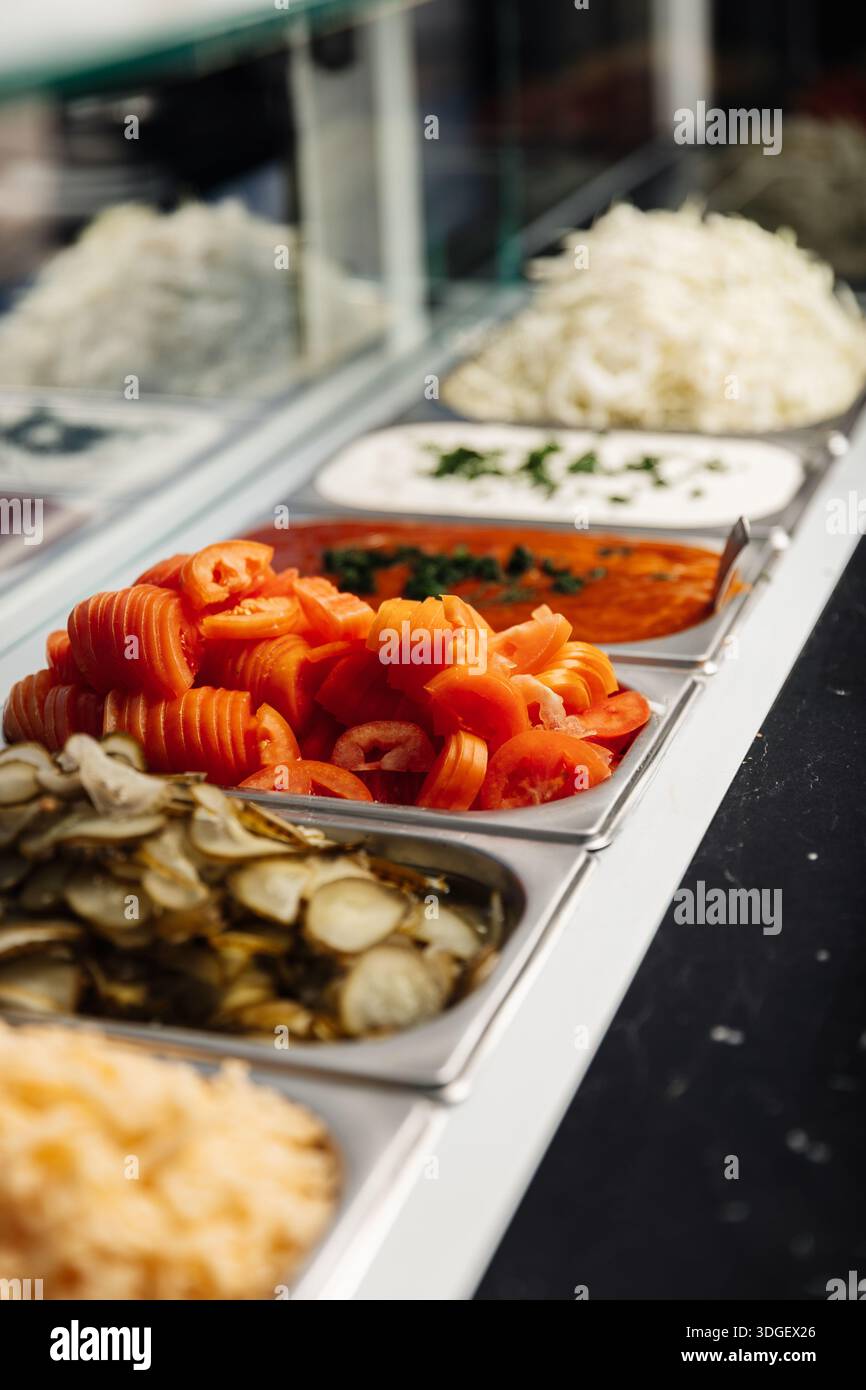 Cetrioli sottaceto, carote, cipolla e salsa fermentata sono conservati in contenitori separati, offrendo ingredienti tenaci e conservati pronti per essere serviti. Foto Stock