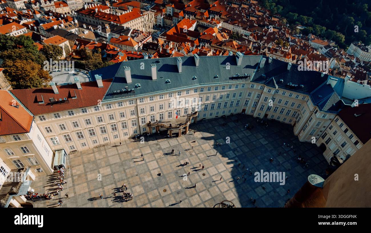 Vista panoramica sul cortile del castello, illuminata dai raggi del sole nei dintorni della piazza barocca, vista aerea del sito storico di Praga Foto Stock
