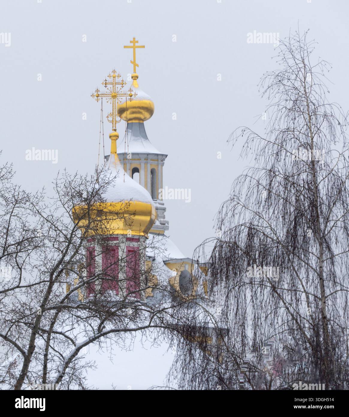 Un campanile di chiesa con una croce sulla parte superiore e una croce d'oro sulla parte superiore. La croce è circondata da oro e argento Foto Stock