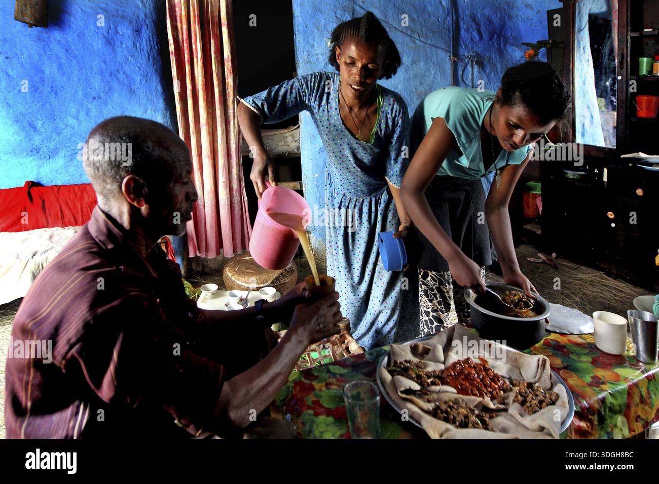 Visita di famiglia a Lalibela, due donne che preparano il pasto sul tavolo, Lalibela, zero Foto Stock