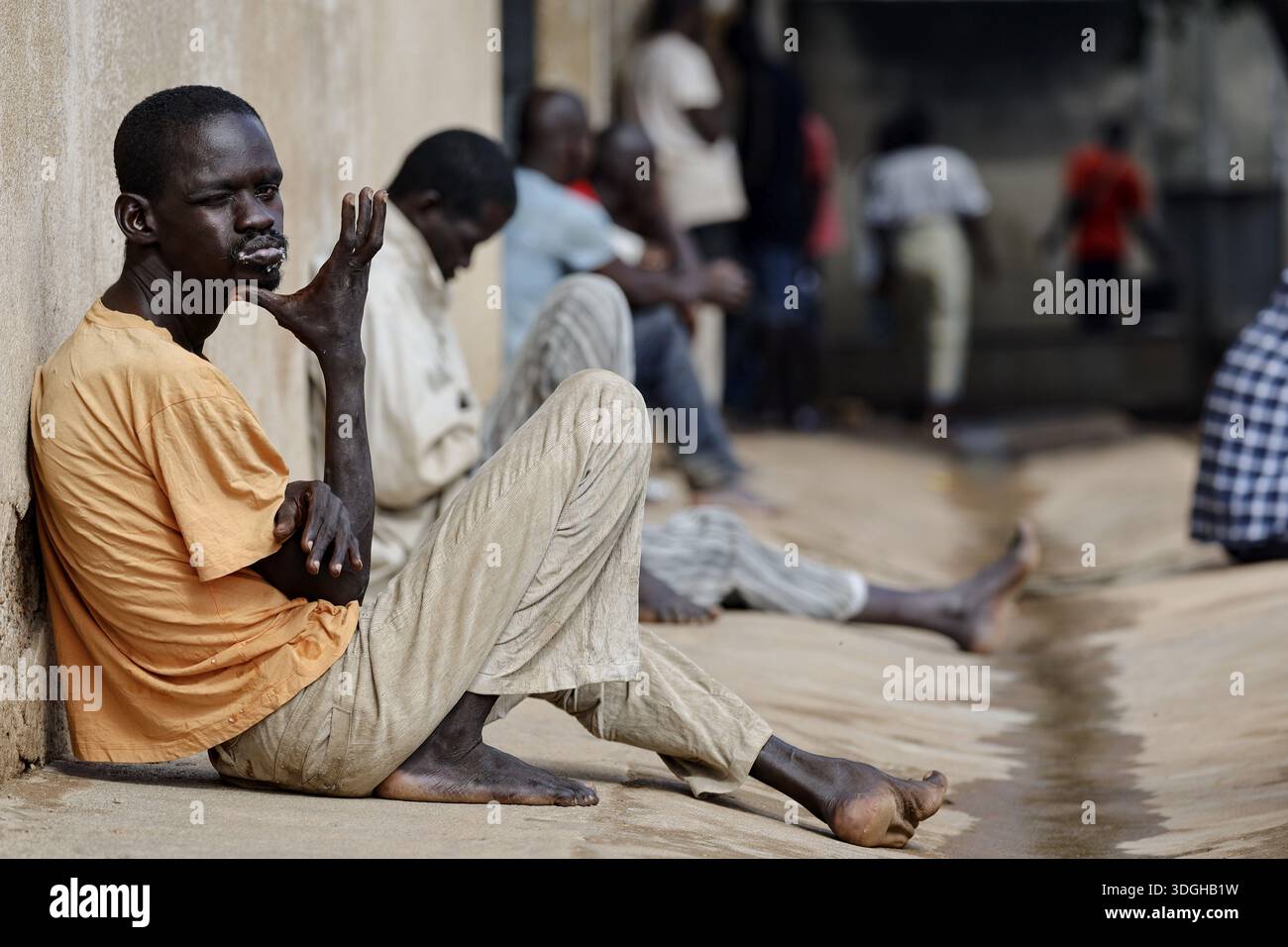 I pazienti siedono sul muro della psichiatria maschile in momenti tranquilli, Bouake, Nimbo, Costa d'Avorio Foto Stock