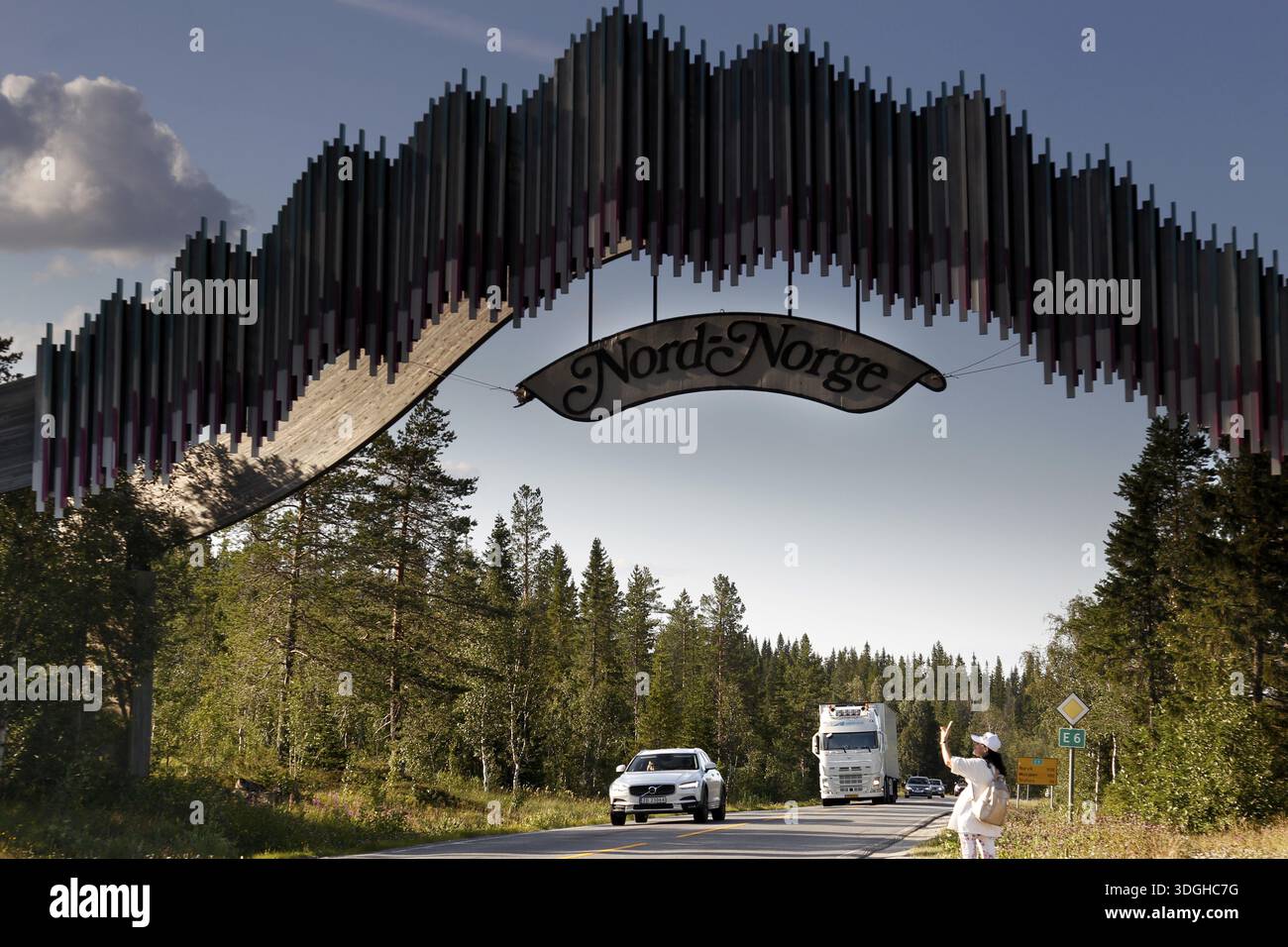 Caratteristico arco in legno dall'altra parte della strada con auto che passano, zero Foto Stock
