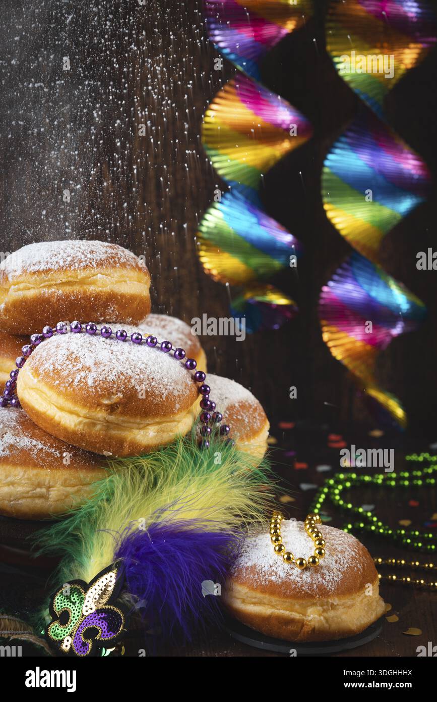 Berliner con zucchero a velo, collane di perle e archi colorati, atmosfera da carnevale, carnevale Foto Stock