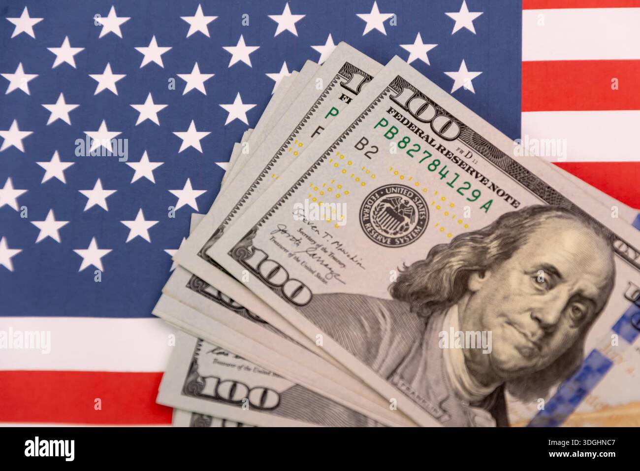 Banconote da cento dollari sullo sfondo della bandiera americana. Foto Stock