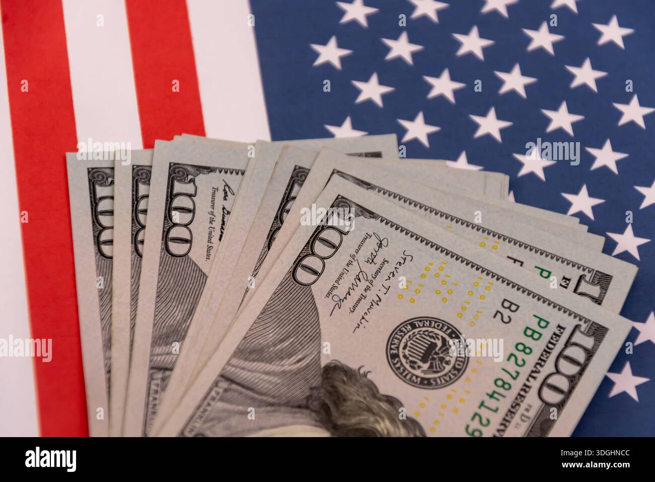 Pila di banconote in dollari USA sulla bandiera degli Stati Uniti. Foto Stock