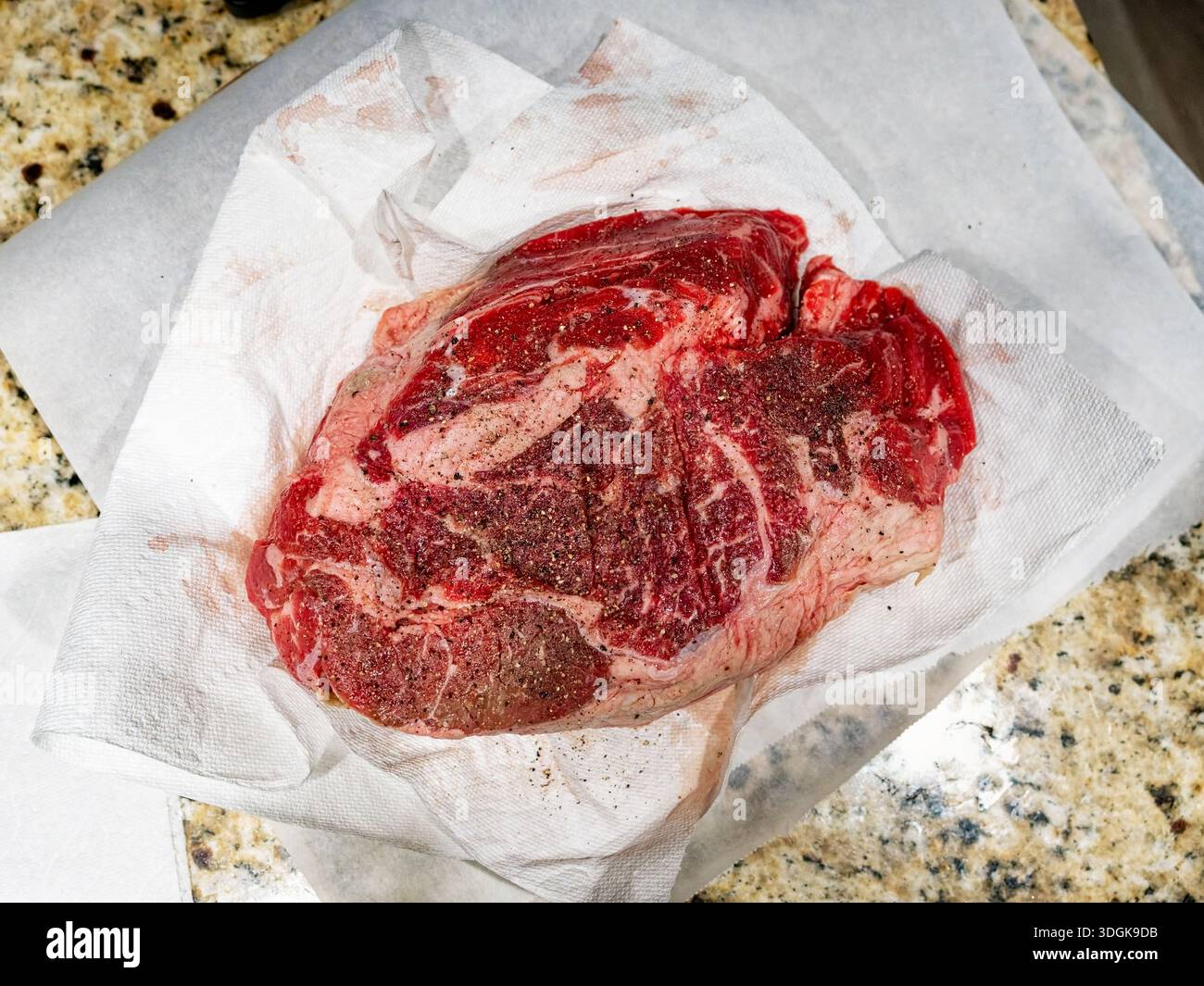 Arrosto di manzo crudo su carta da macelleria pronto per la cena. Foto Stock