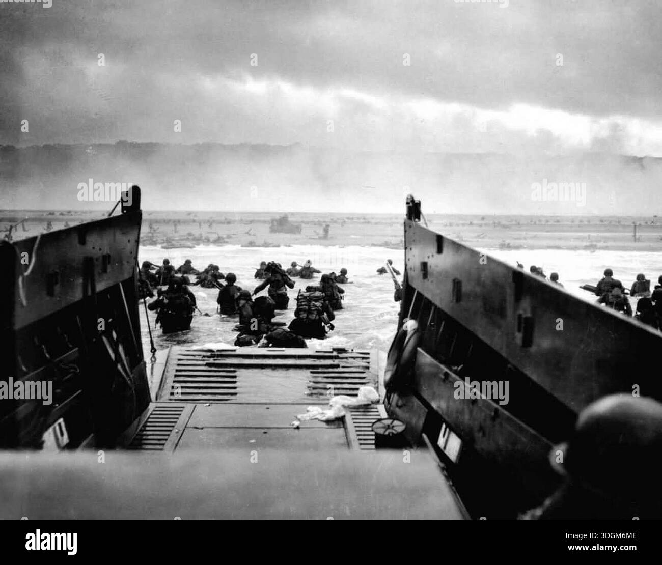 Le truppe STATUNITENSI si gettano a terra sulla spiaggia di Omaha il D-Day. Il 6 giugno 1944 un'enorme forza d'invasione Alllied che coinvolgeva 7000 navi e 140.000 uomini sbarcò con successo sulla costa francese e stabilì cinque teste di spiaggia. Una campagna di inganno di successo significò che gran parte della resistenza tedesca si trovava a Calais e le perdite furono relativamente poche per le dimensioni e i rischi dell'operazione. Foto Stock