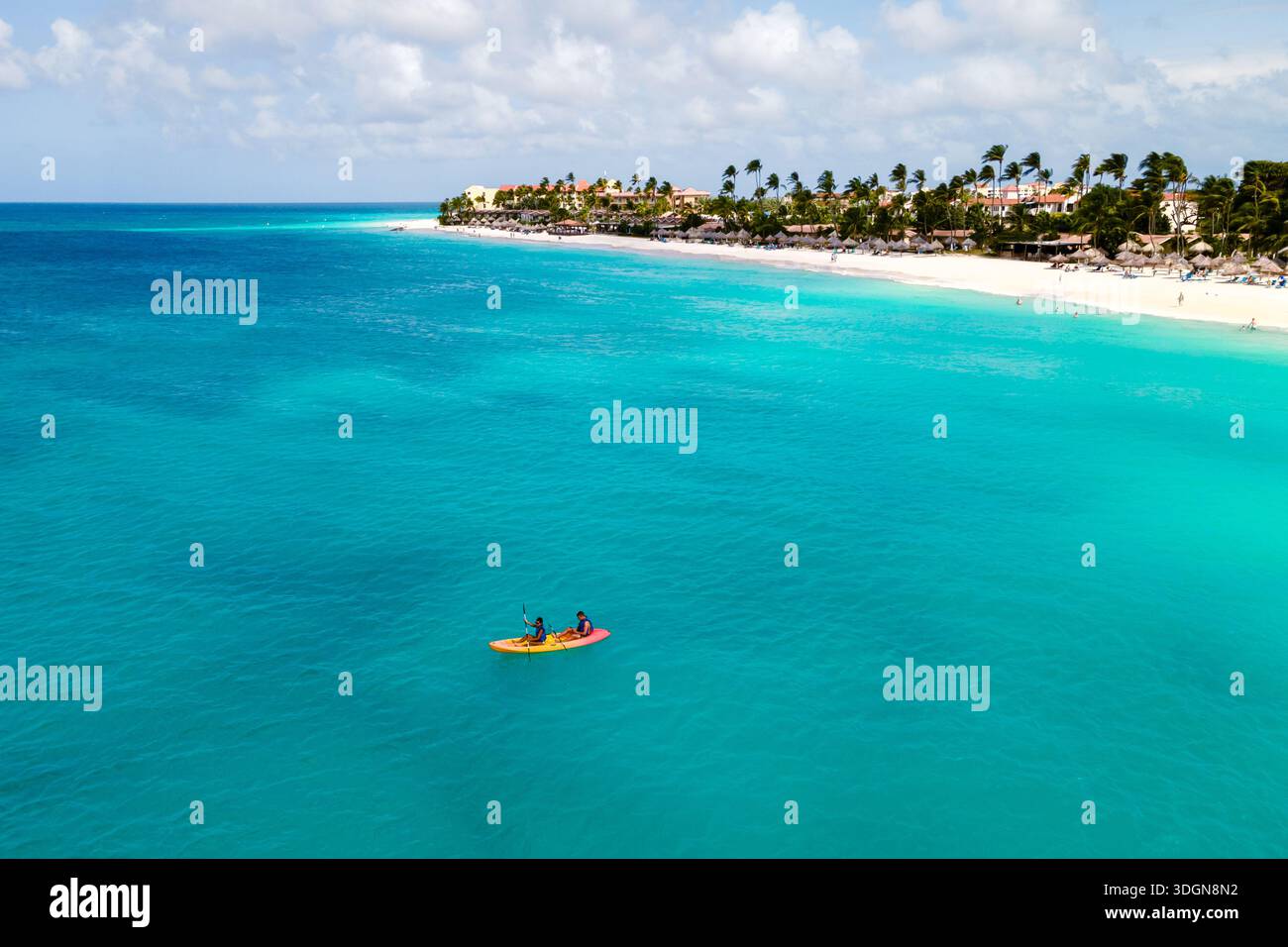Due persone avventurose pagaiano su un kayak colorato nelle tranquille acque turchesi di Divi Beach ad Aruba. Foto Stock