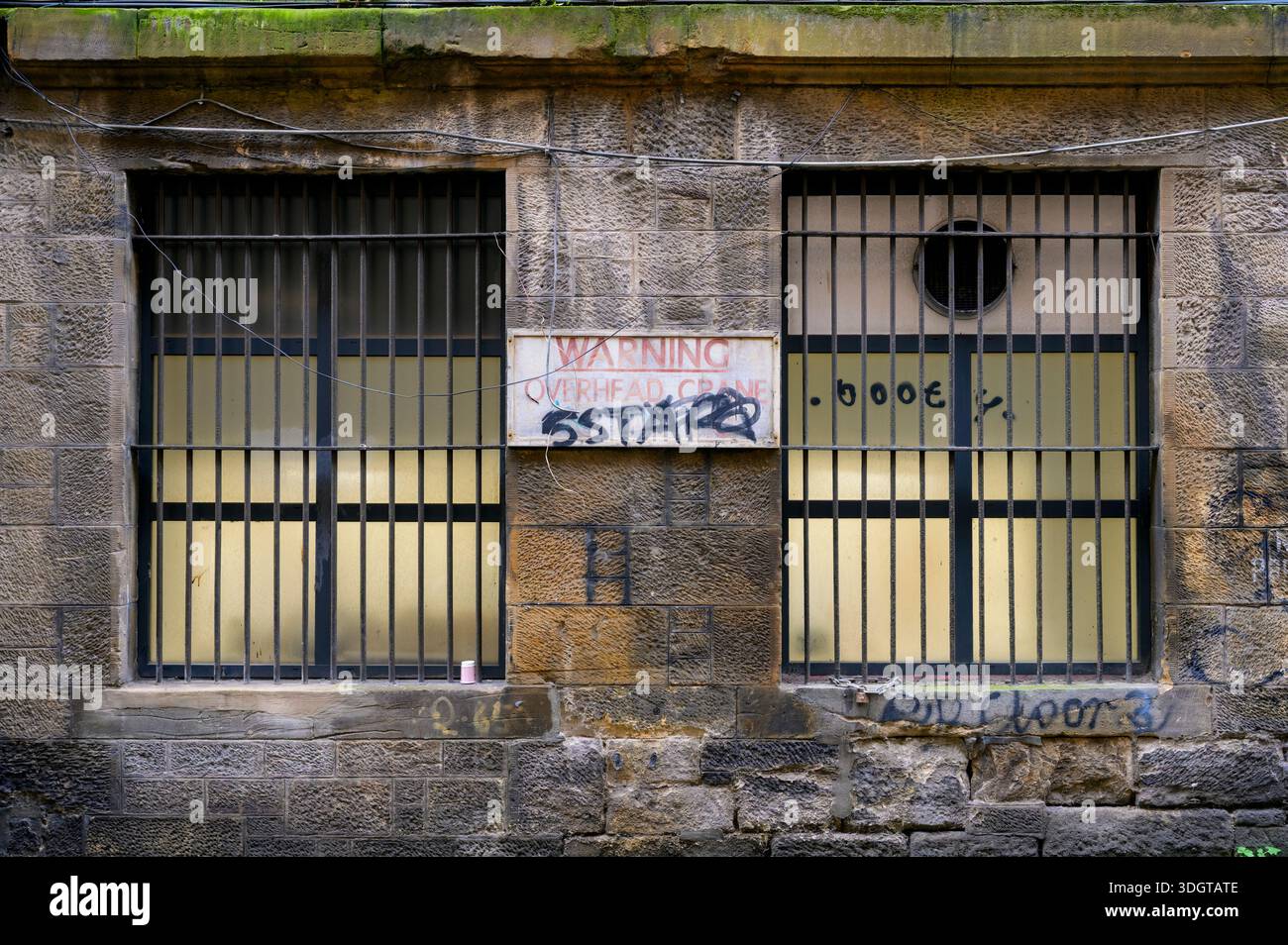 Finestre con barre in un vecchio edificio in pietra, Regno Unito Foto Stock