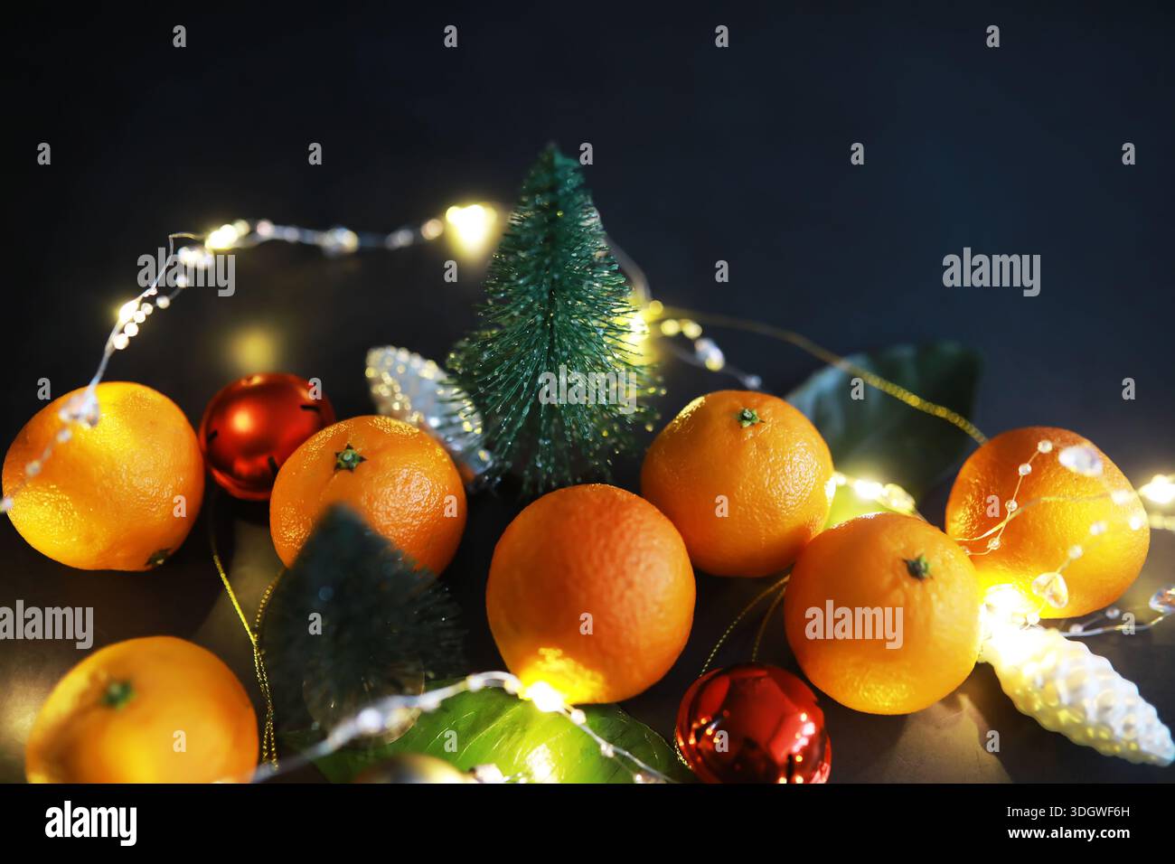 Agrumi su sfondo grigio. Tangerini con foglie. Frutta di Natale. Foto Stock
