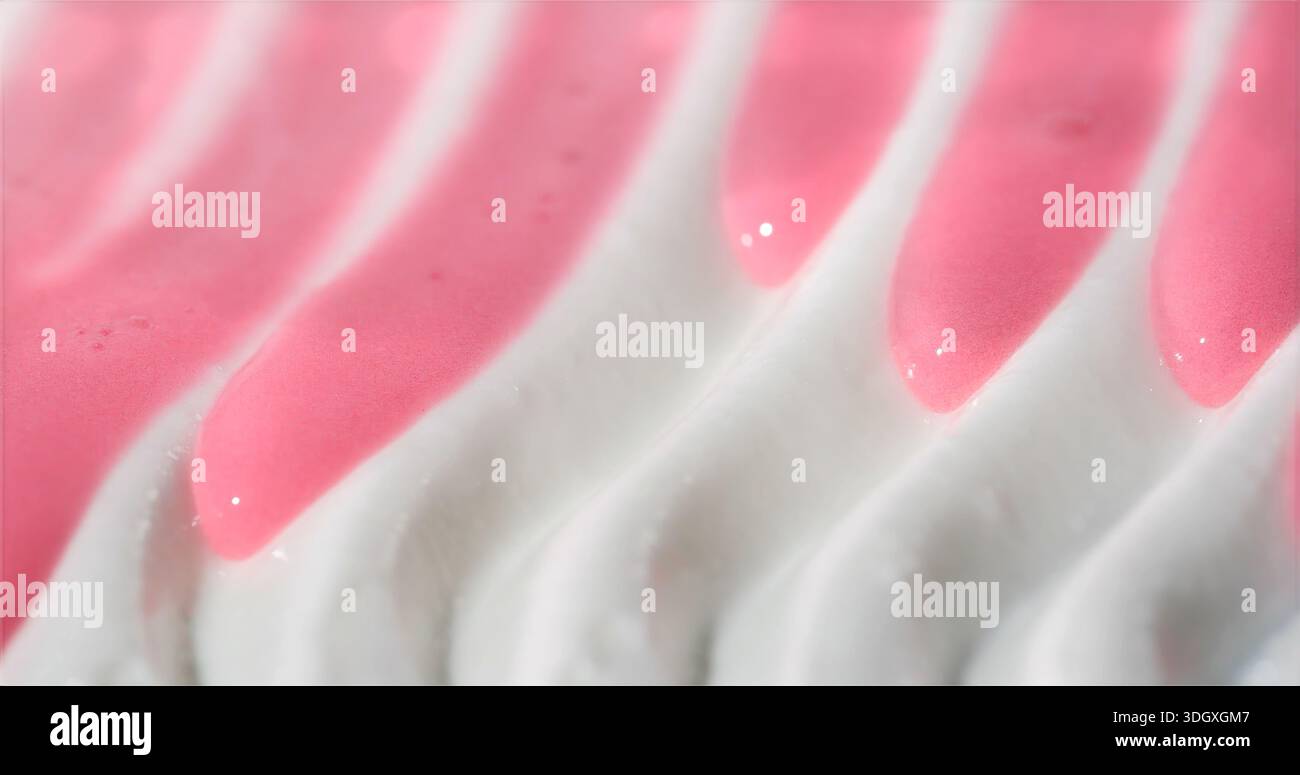 Macro Shot presenta una Meringa cremosa avvolta da una lucentezza rosa liscia con motivi decorativi vorticosi Foto Stock