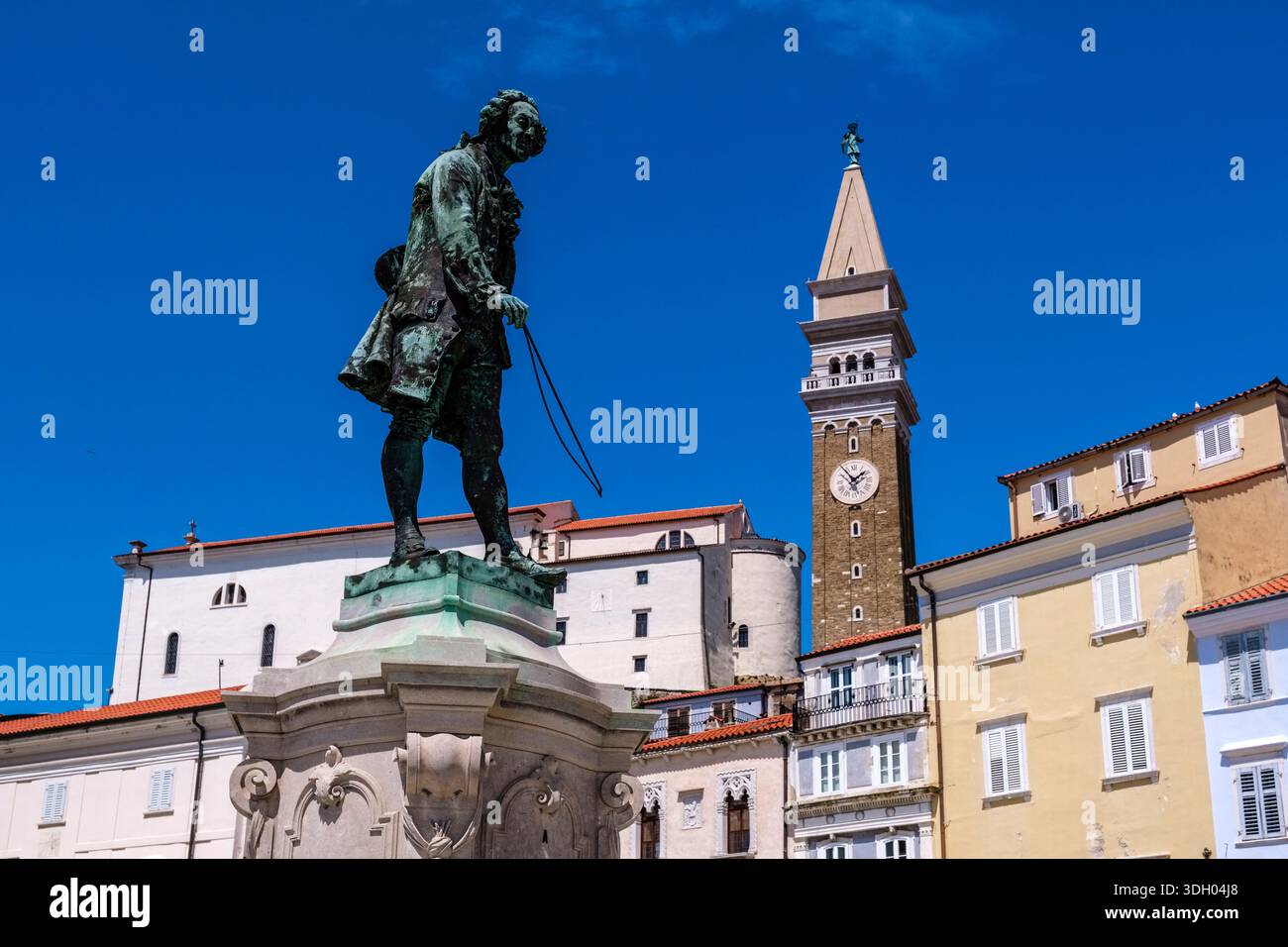 Statua in bronzo di Giuseppe Tartini su Piazza centrale Tartini con la Chiesa Parrocchiale di San Giorgio e il suo campanile in stile veneziano in lontananza. Foto Stock