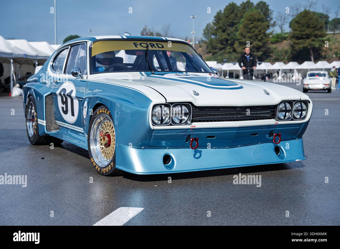 Vista frontale ravvicinata di un'impressionante auto da corsa Ford Capri RS 3100 blu e bianca del 1975, che mostra le sue ruote dorate con lucchetto centrale, nel paddock Foto Stock
