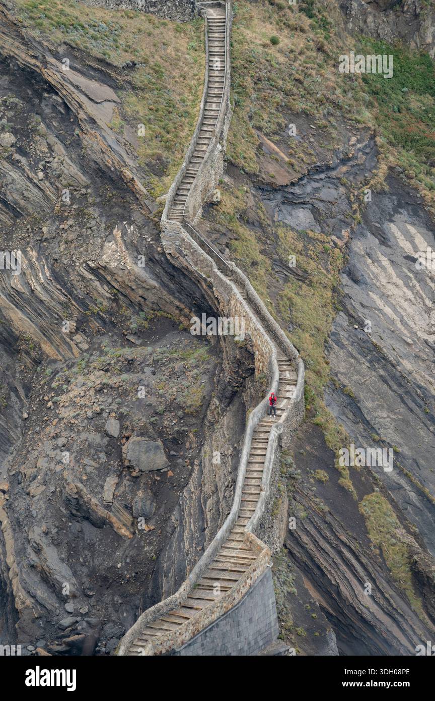 Infiniti gradini di pietra a zigzag su un pendio roccioso in riva al mare. Foto Stock
