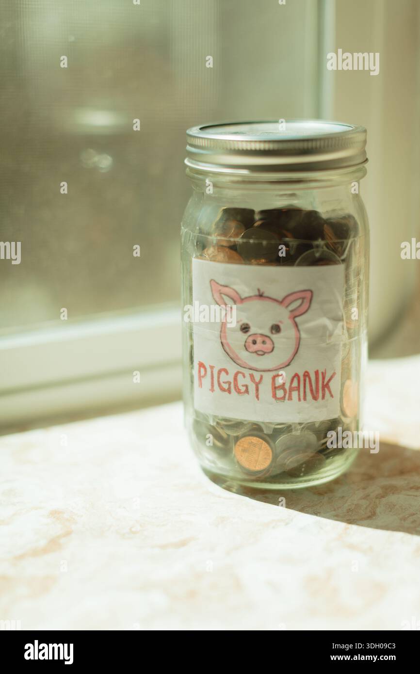 Vaso salvadanaio fai da te pieno di monete Foto Stock