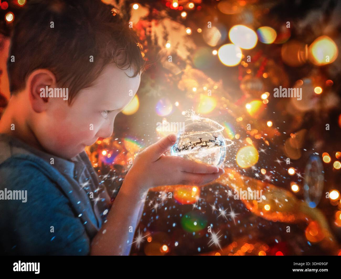 Ragazzo che guarda nel Snow Globe con le luci magiche Foto Stock
