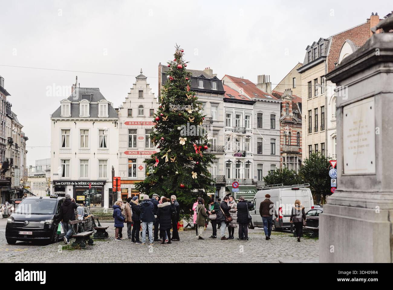 La gente si riunisce intorno all'albero di Natale nella piazza del quartiere di Bruxelles Foto Stock