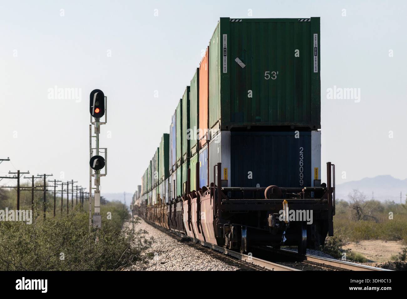 Fine del treno di contenitori impilati che si allontana dallo spettatore Foto Stock