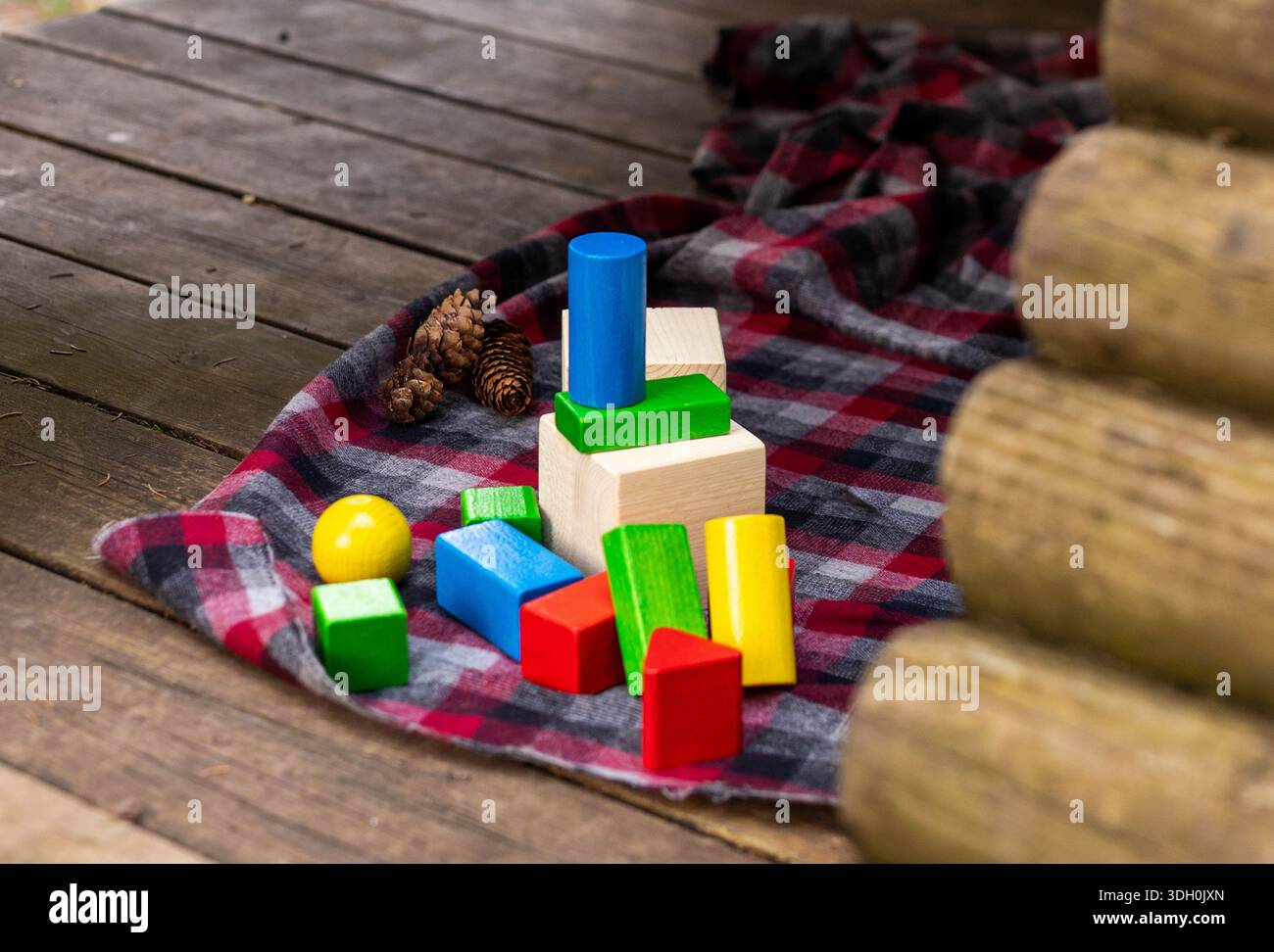 Piastrelle e blocchi di legno naturale sparsi all'aperto. Giocattolo ecologico e tattile. Foto Stock