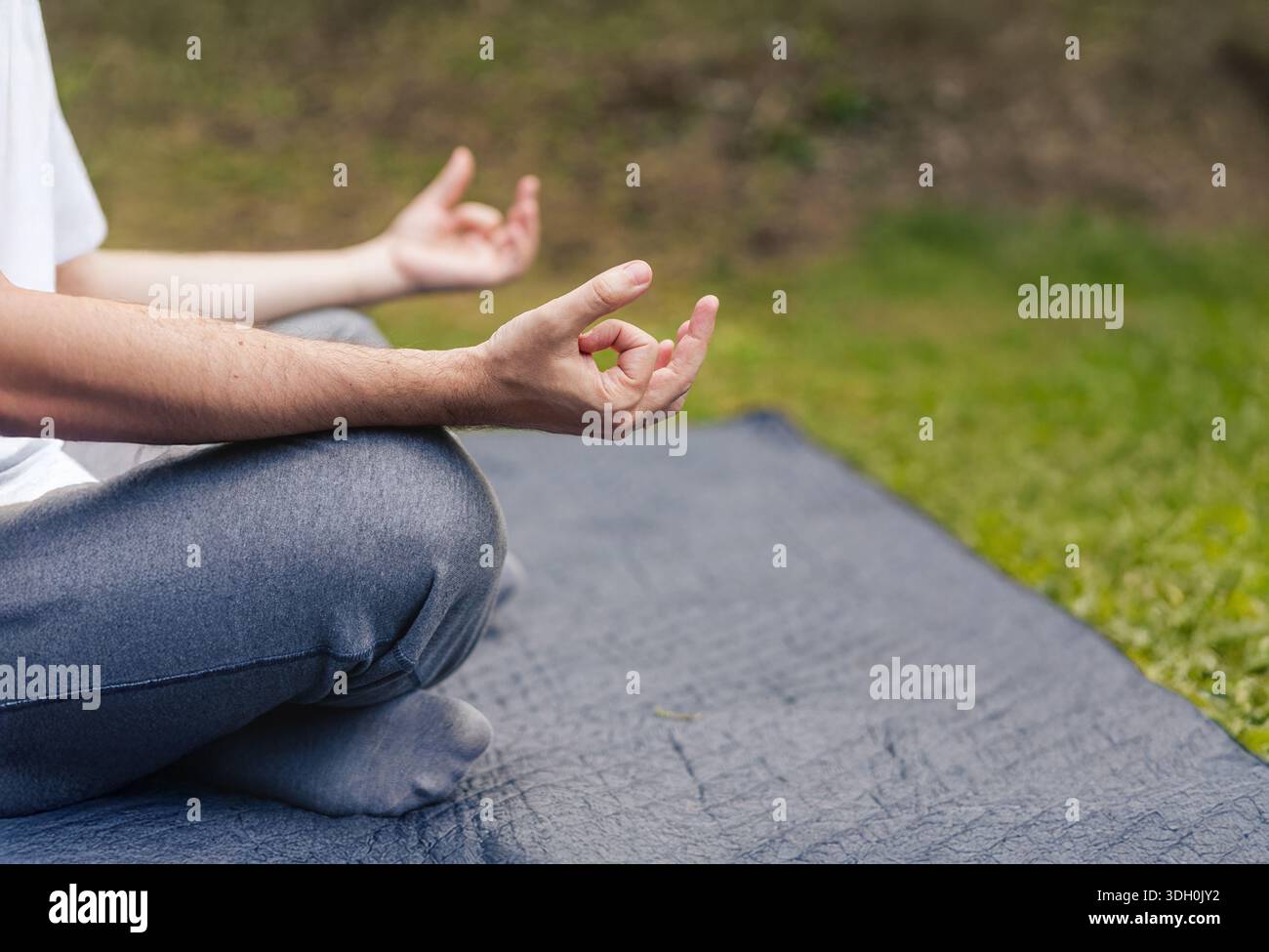 Primo piano del gesto di Gyan Mudra durante una sessione di yoga all'aperto. Composizione con ampio spazio di copia per testo e grafica. Foto Stock
