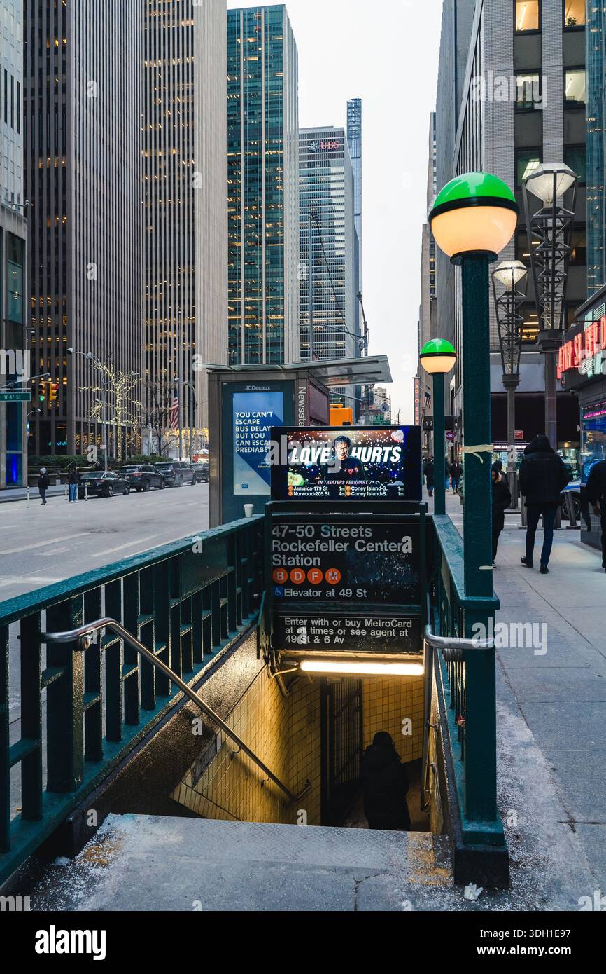 Un ingresso alla stazione della metropolitana di Rockefeller Center in Midtown Manhattan, circondato da alti edifici di uffici e trafficati marciapiedi della città. Foto Stock