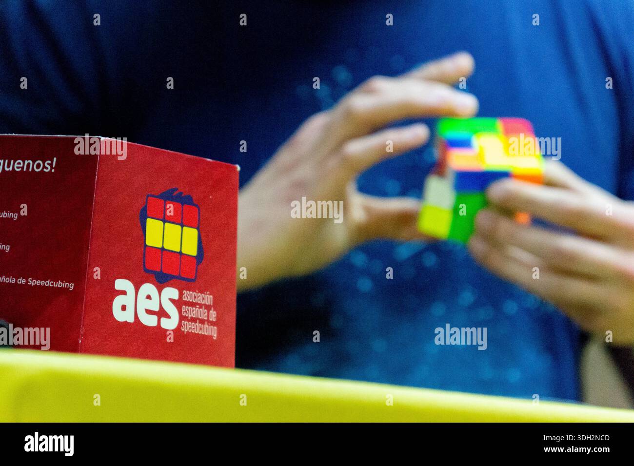 Mani che risolvono il cubo di Rubik durante una gara di speedcubing, mostrando abilità, concentrazione e rompicapo. Spagna. Foto Stock