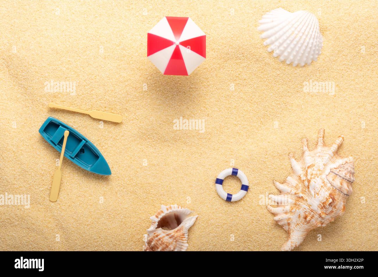 Sfondo estivo alla luce del sole di tendenza realizzato con conchiglie marine e oggetti estivi su sfondo sabbia. Concetto estivo minimalista. Foto Stock