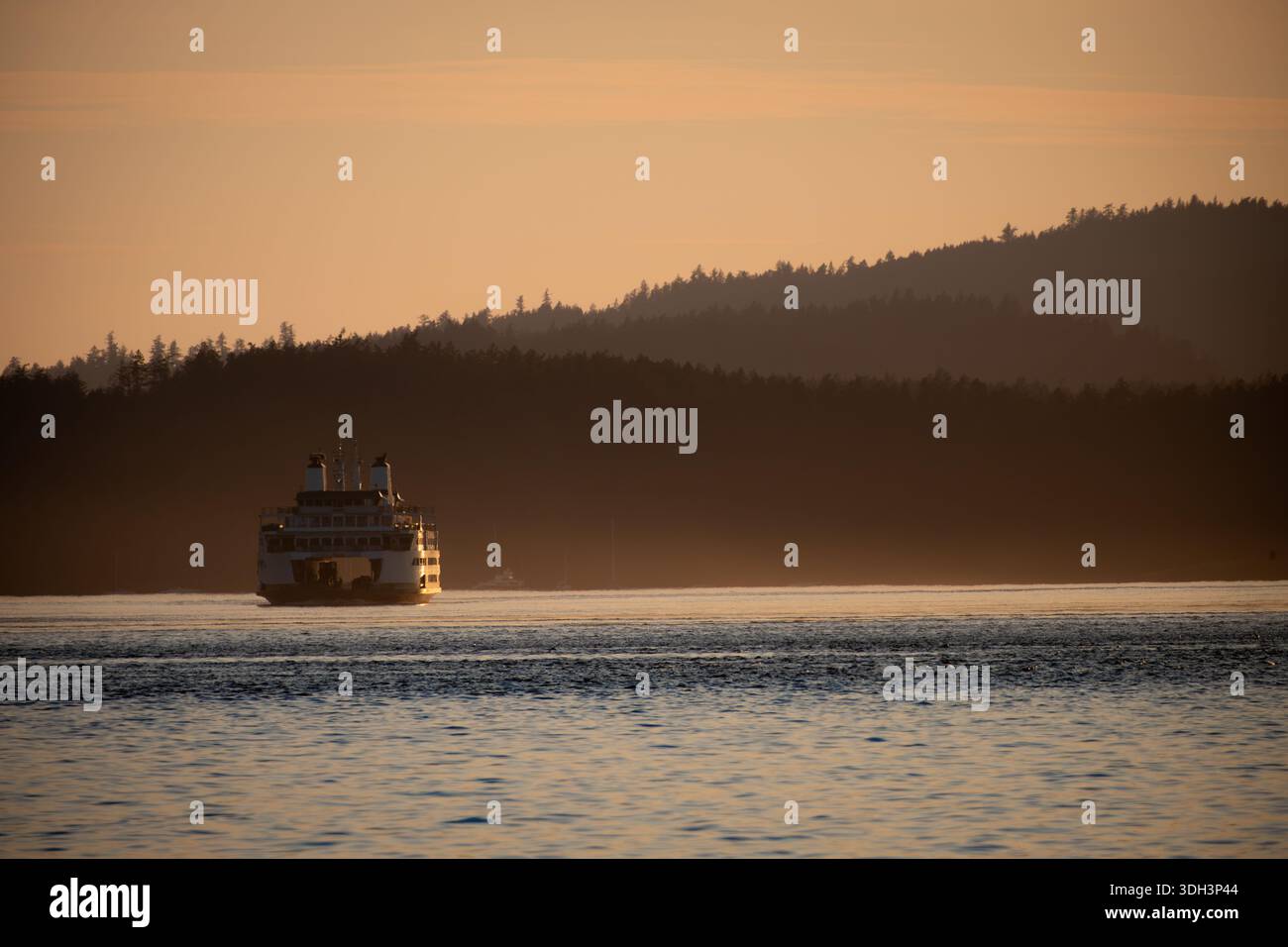 Il sole tramonta sul traghetto in mare vicino a Victoria, Canada Foto Stock