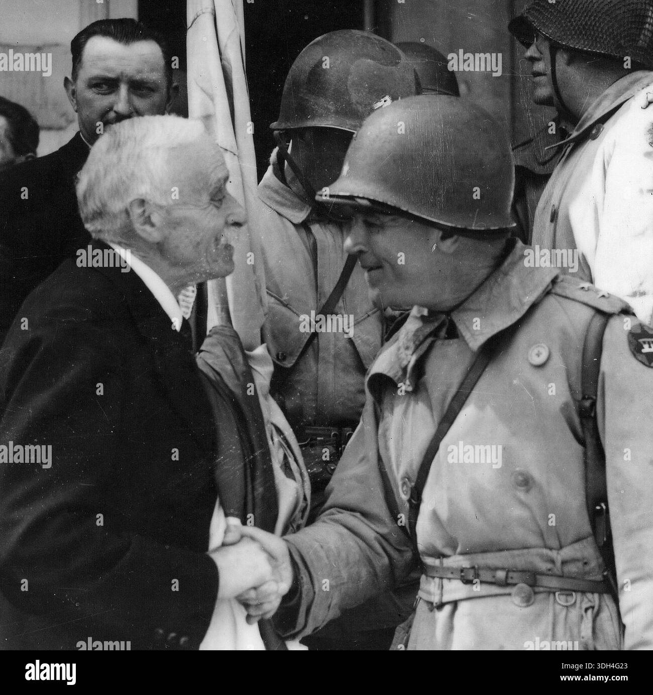 Il sindaco di Cherbourg Paul Renault ringrazia il generale Collins per aver liberato la città dopo il D-Day. La cattura della città era vitale, in quanto Cherbourg è un porto di acque profonde in grado di gestire grandi navi. Il 6 giugno 1944 un'enorme forza d'invasione Alllied che coinvolgeva 7000 navi e 140.000 uomini sbarcò con successo sulla costa francese e stabilì cinque teste di spiaggia. Una campagna di inganno di successo significò che gran parte della resistenza tedesca si trovava a Calais e le perdite furono relativamente poche per le dimensioni e i rischi dell'operazione. Foto Stock